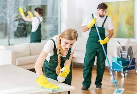 A team of people from a home cleaning service tidying up a room together.