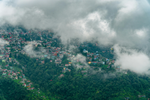 Misty hill town surrounded by green mountains and clouds