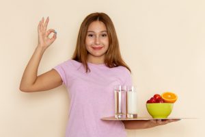 young woman holding fruits milk and water for healthy weight loss diet