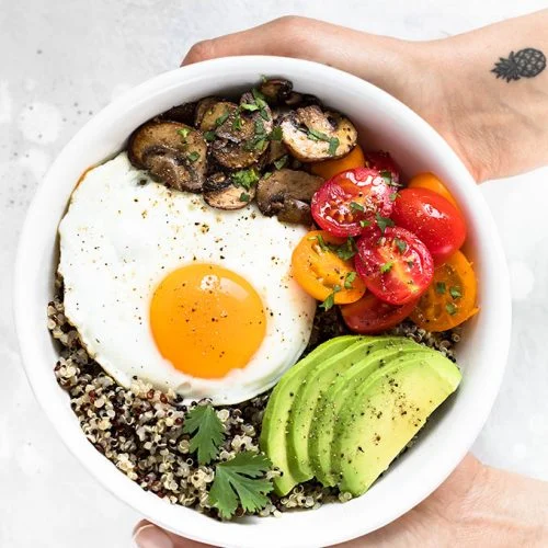 Healthy brown rice breakfast bowl with egg and avocado