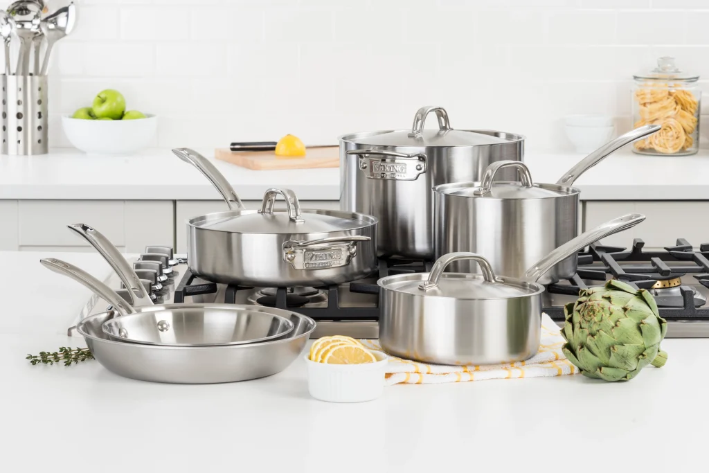 Tri ply stainless steel cookware sets arranged on a clean kitchen counter