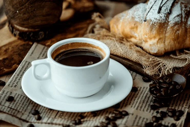 A cup of espresso coffee served with beans, showing the rich character of americano and strong brewed drink.