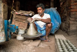 An-Indian-potter- painting- handmade- terracotta-diyas-in- a-traditional-pottery- workshop